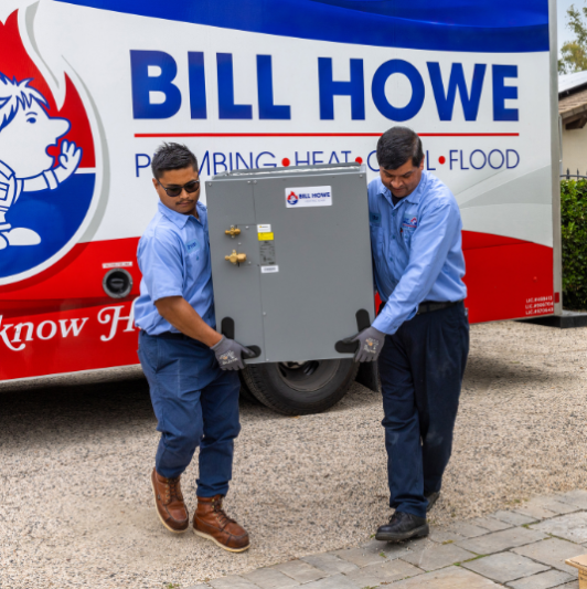 Technicians carrying a new HVAC system an AC installation.